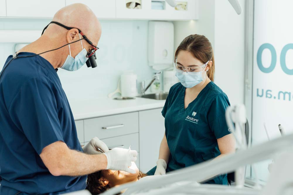 Photo of a male dentist and female assistant checking the teeth of a patient | featured image for Dental Prosthodontics.