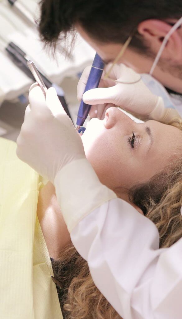 Blonde haired patient receiving dental work | Featured Image for the Dental Services Page of Restore Dental.