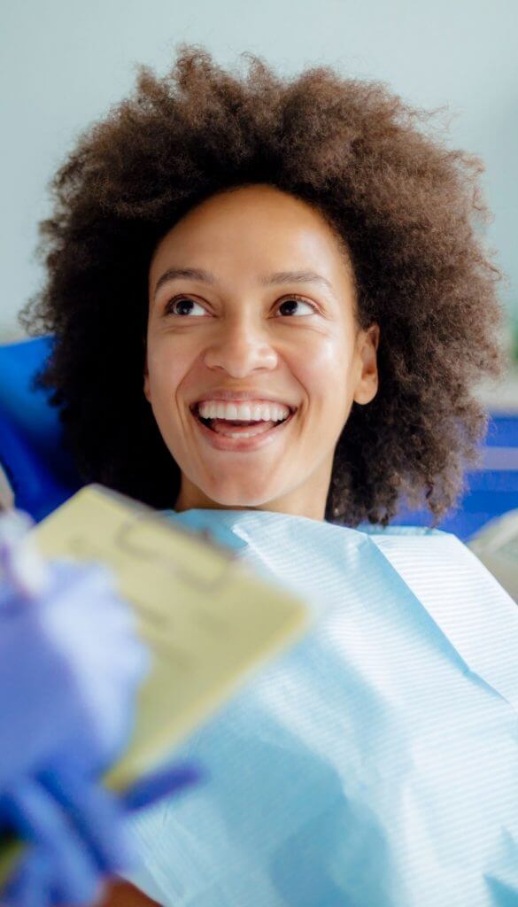 Smiling patient talking to a dentist | Featured Image for the Dental Services Page of Restore Dental.