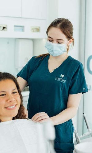 Seated and smiling patient and a female Chermside dentist technician | Featured Image for the Chermside Dentist Home Page of Restore Dental.