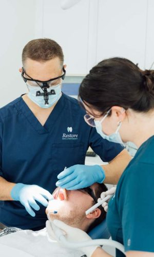 Man having his teeth examined by two Restore Dental team members | Featured Image for the Chermside Dentist Home Page of Restore Dental.